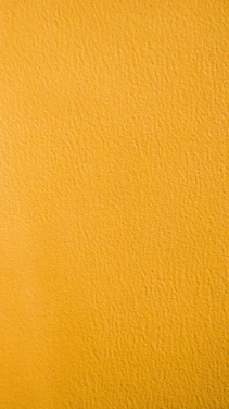 a close up of a yellow painted wall