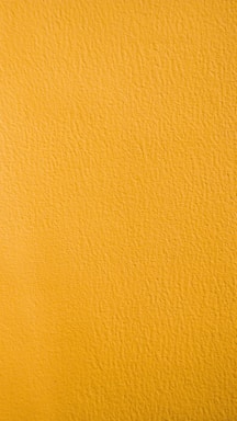 a close up of a yellow painted wall