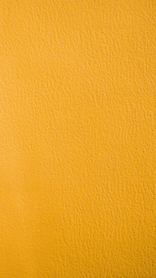 a close up of a yellow painted wall