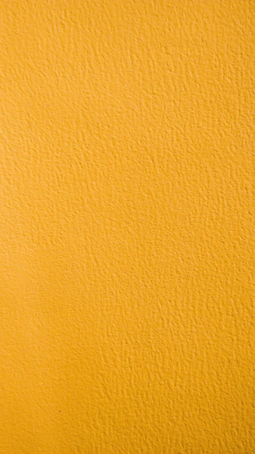 a close up of a yellow painted wall