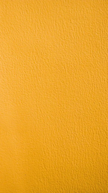 a close up of a yellow painted wall