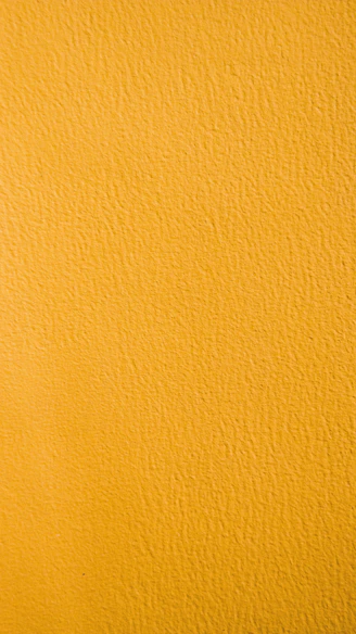a close up of a yellow painted wall