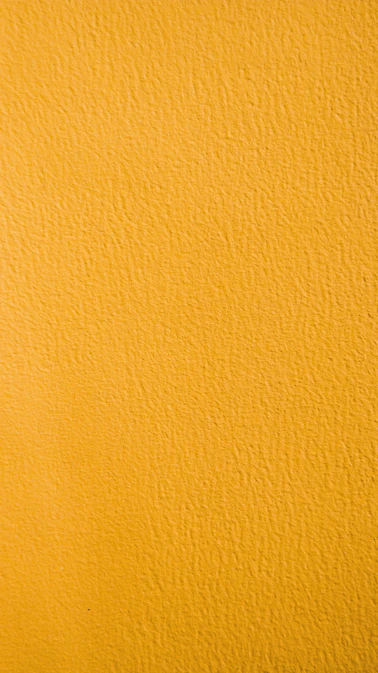 a close up of a yellow painted wall