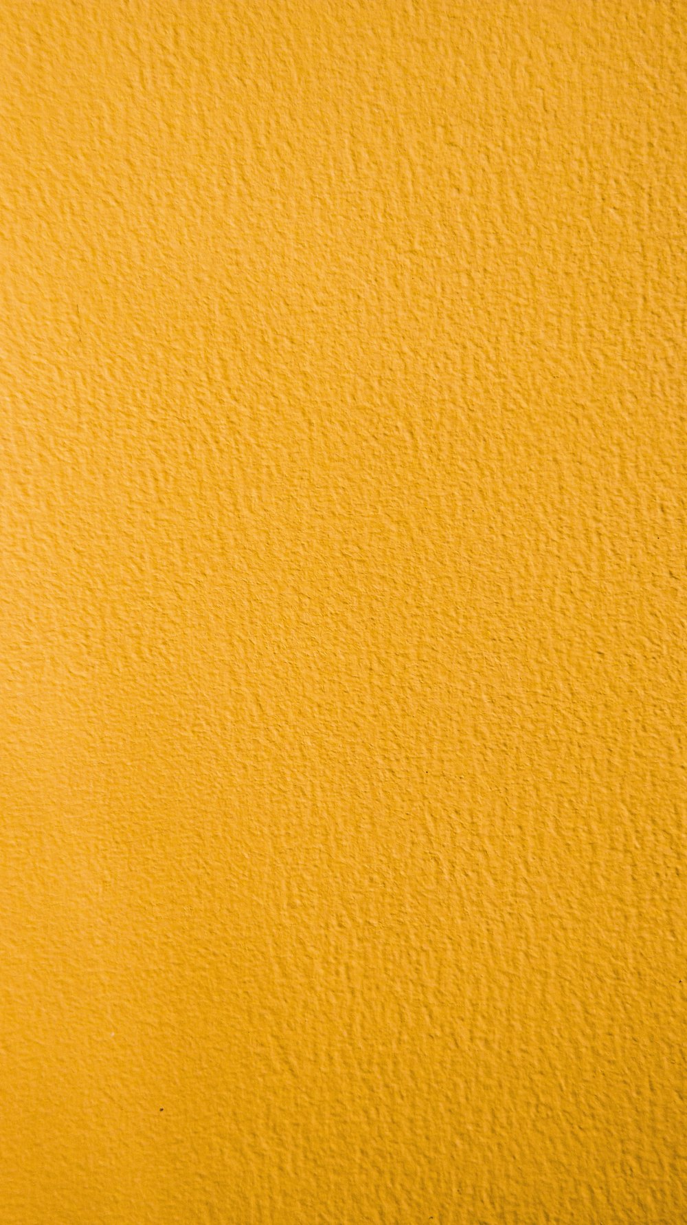 Un primer plano de una pared pintada de amarillo