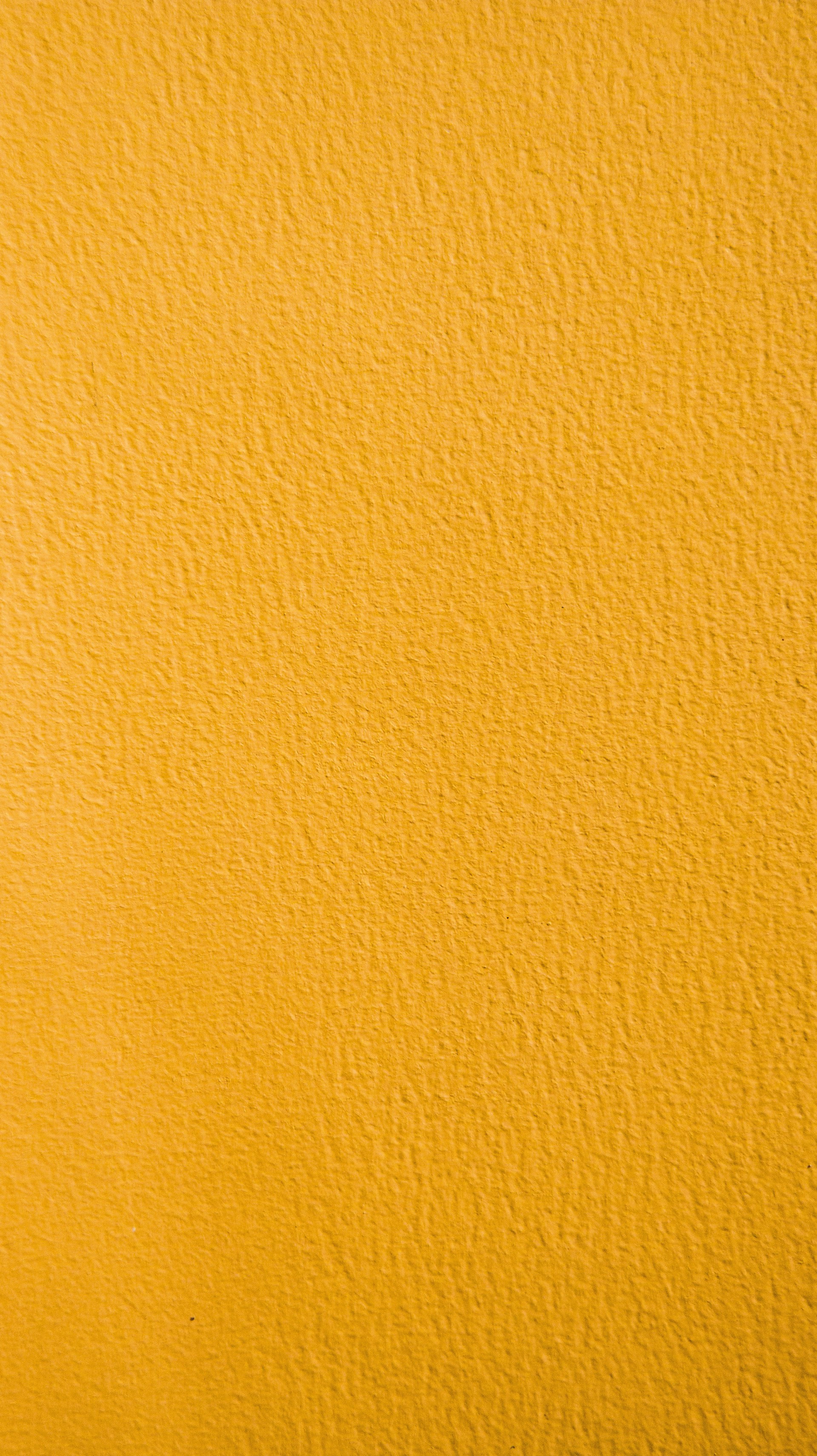 a close up of a yellow painted wall