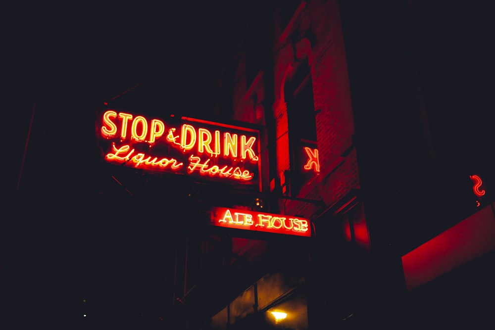 a neon sign that reads stop and drink