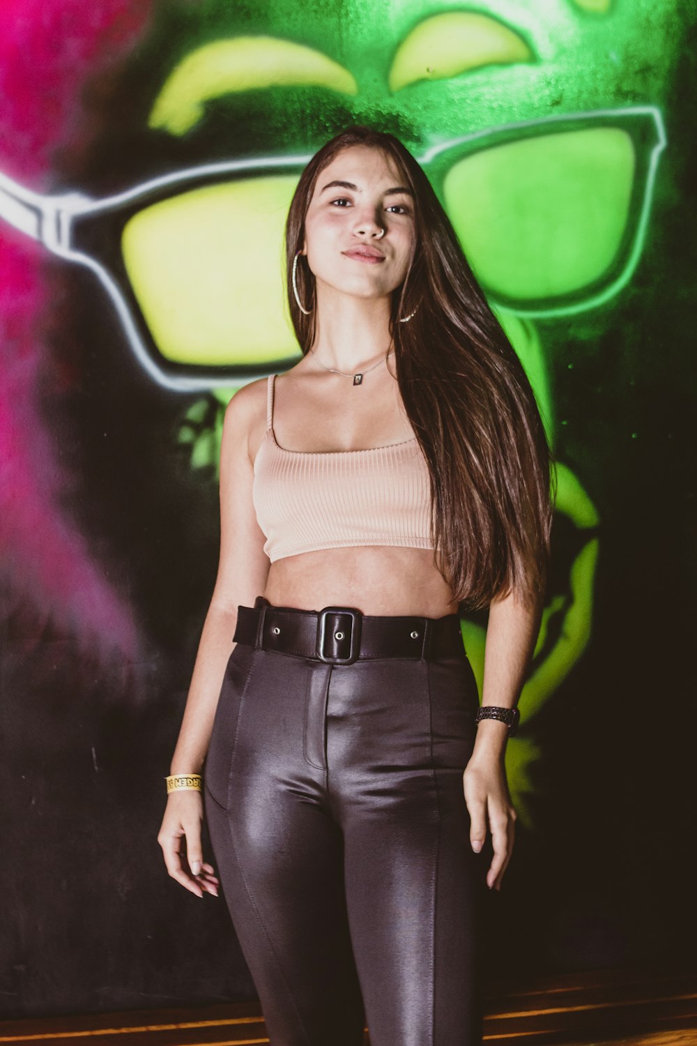 a woman standing in front of a graffiti wall