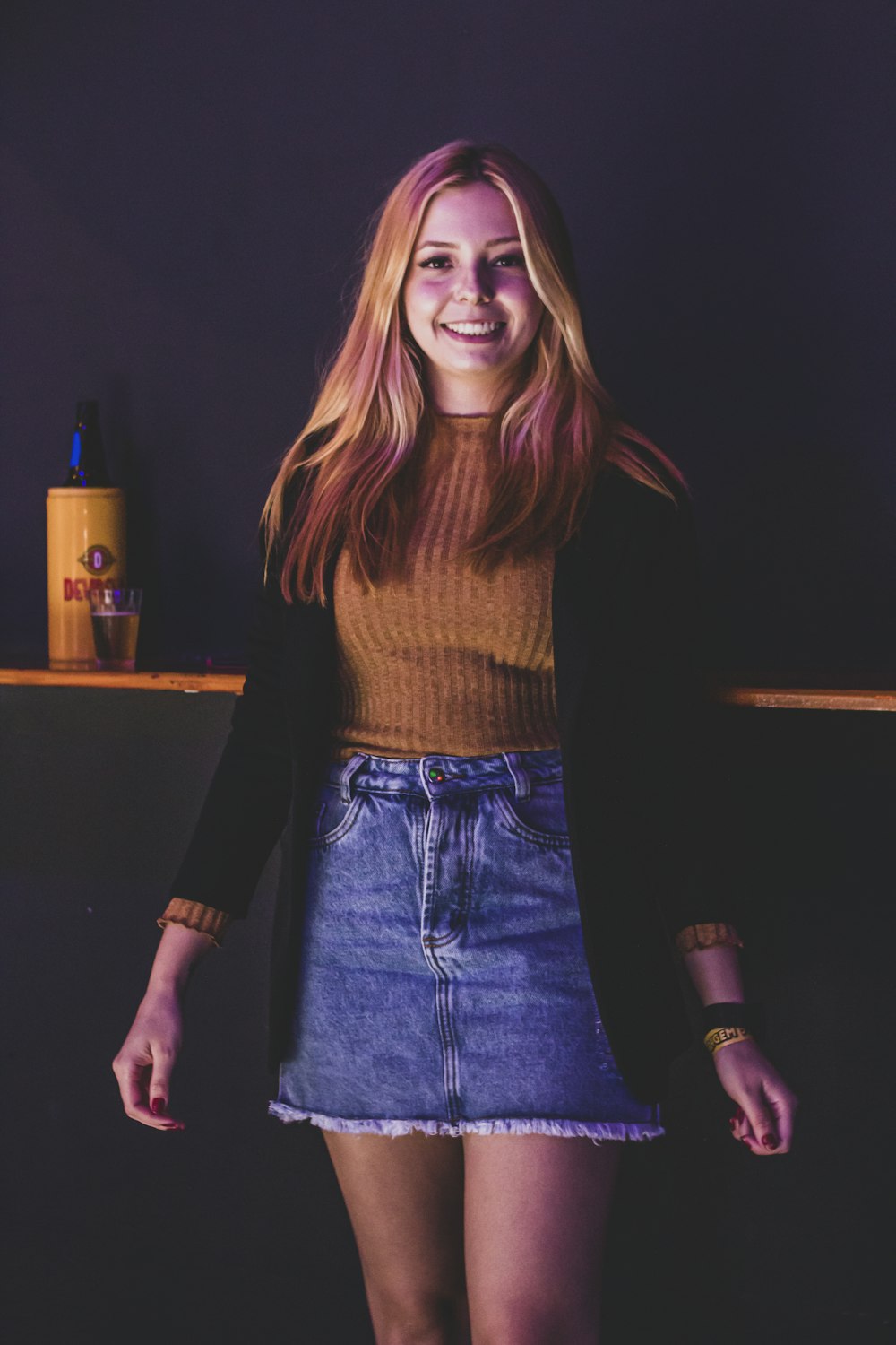 a woman standing in front of a purple wall