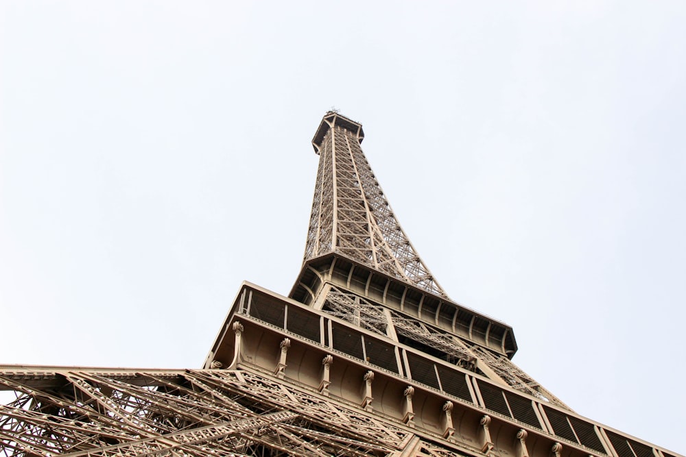 the top of the eiffel tower against a blue sky