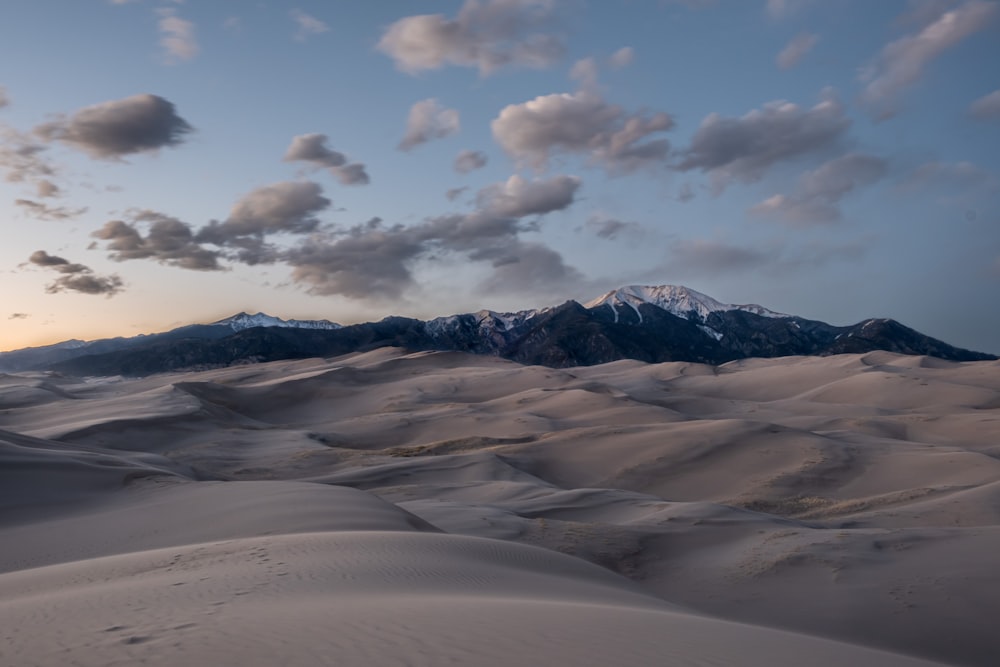 a view of a mountain range from a sand dune