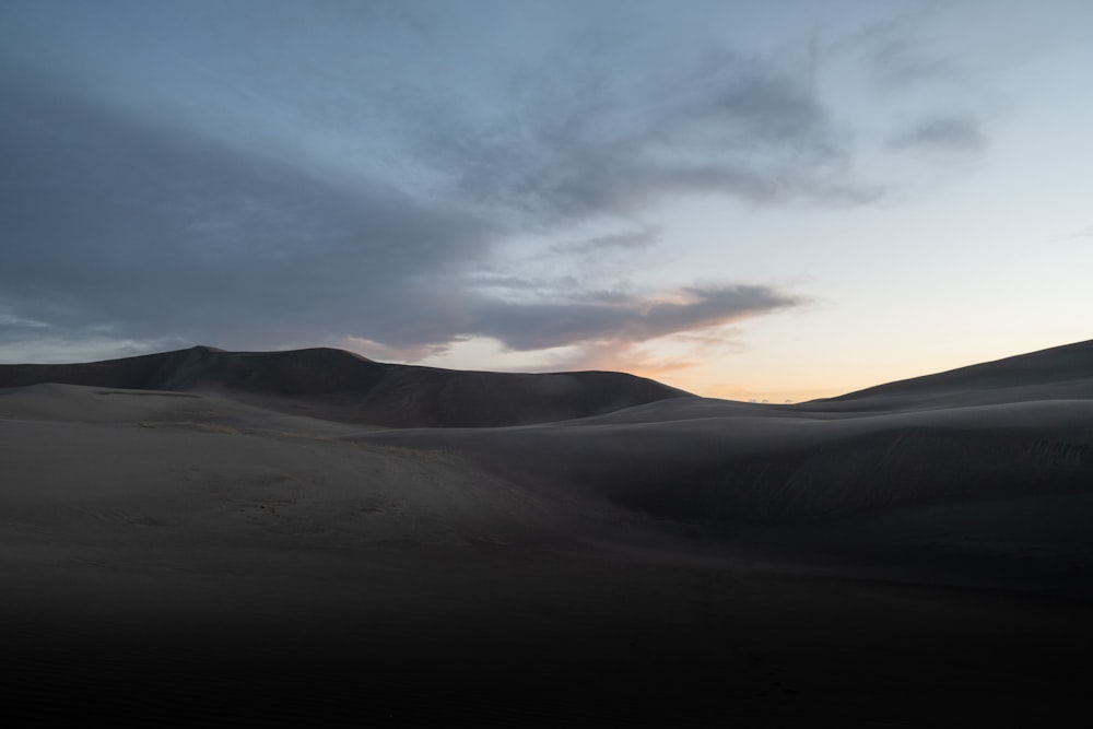 the sun is setting over the mountains in the desert