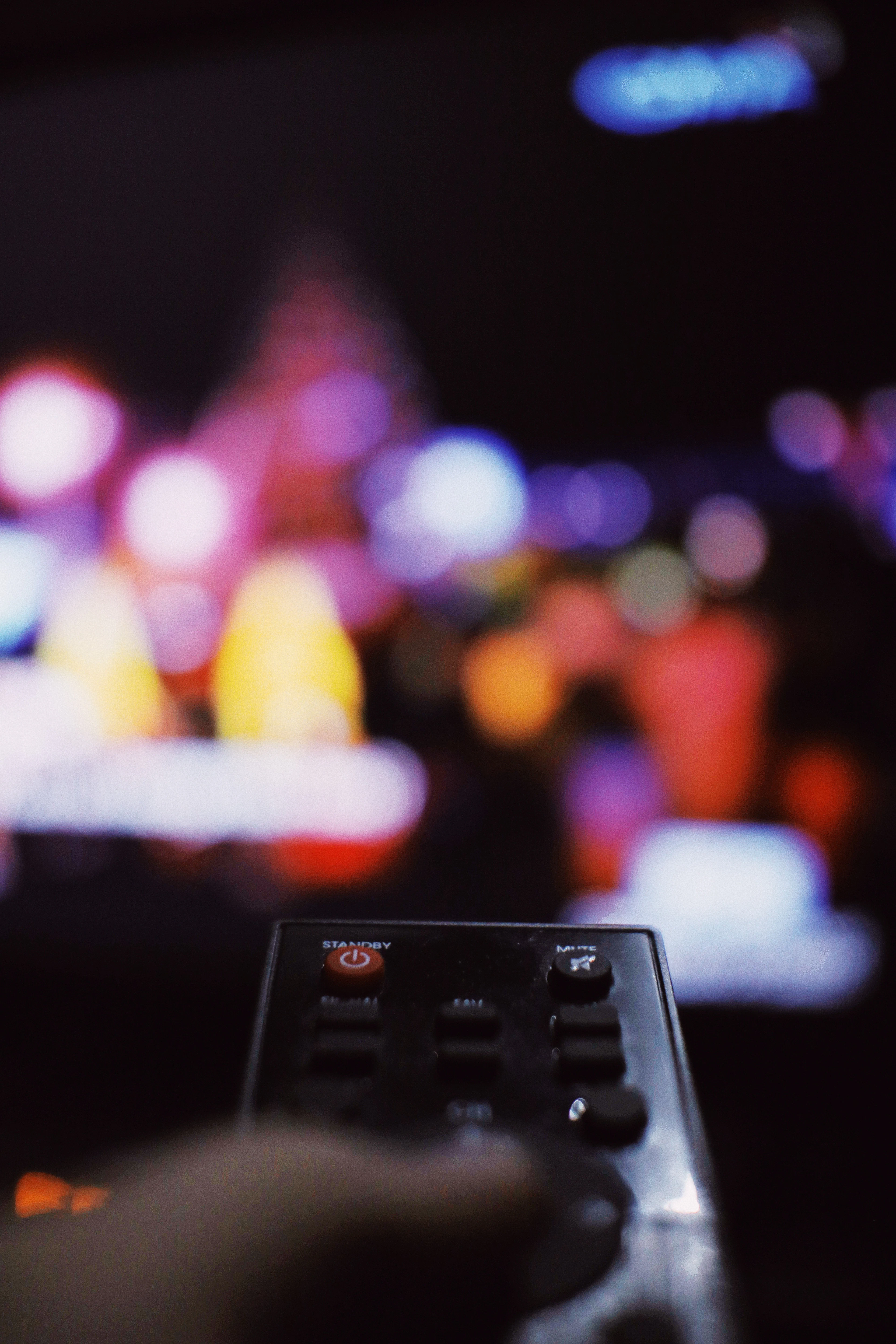 Remote control pointed at a glowing TV screen