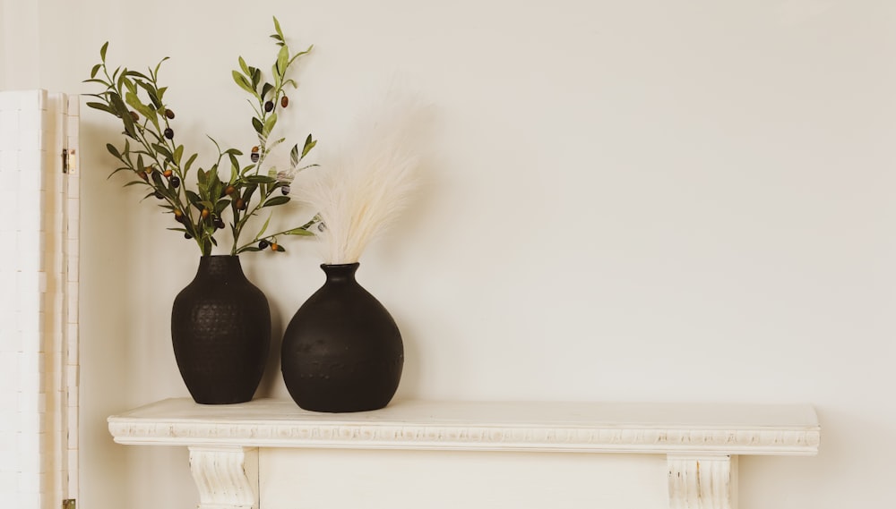 a couple of vases sitting on top of a mantle