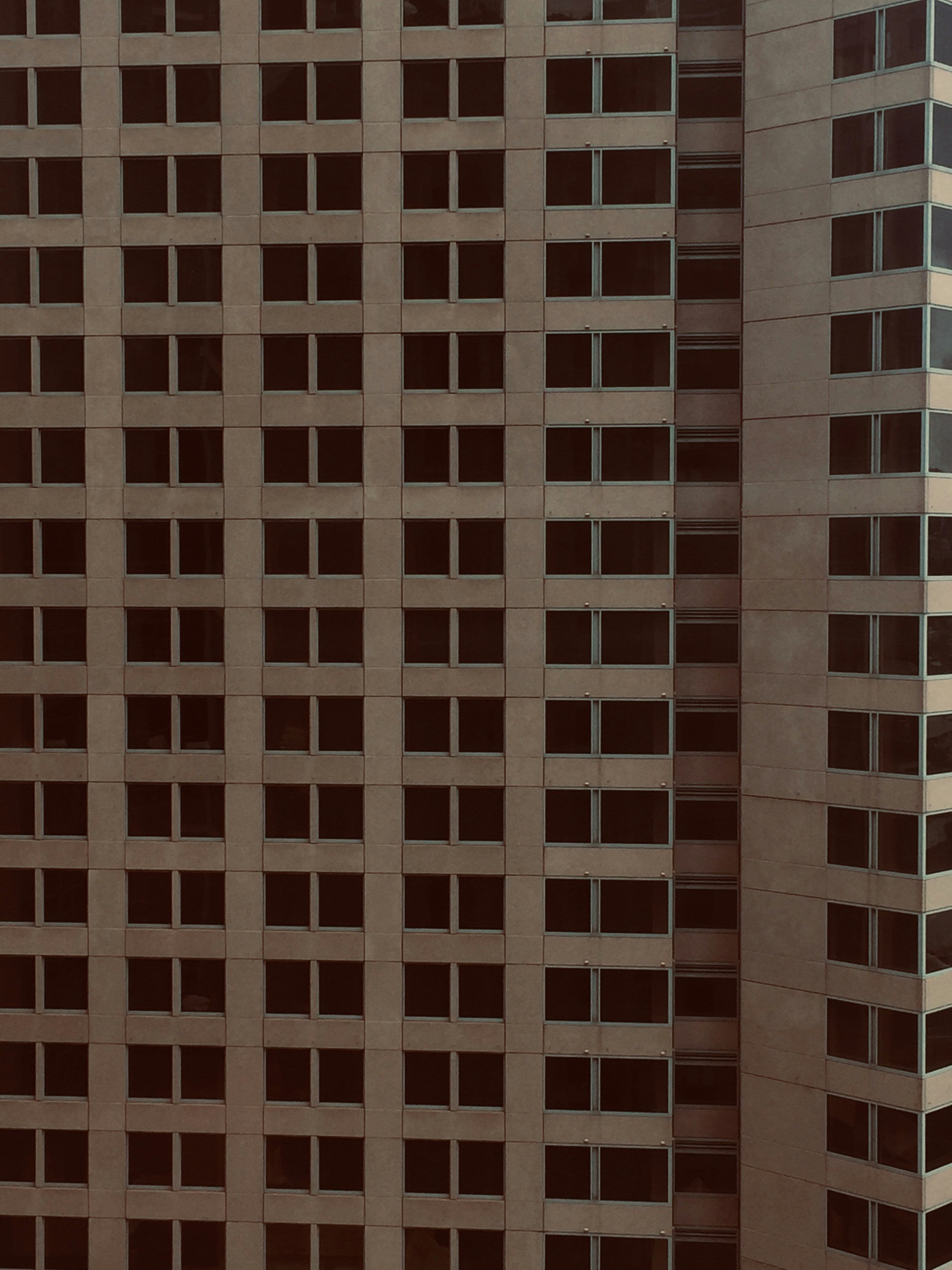 an airplane flying in front of a very tall building