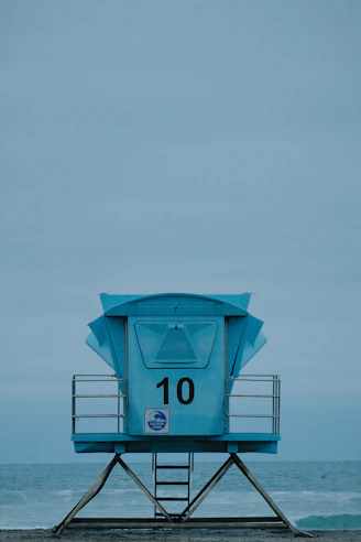 a lifeguard tower sitting on top of a sandy beach