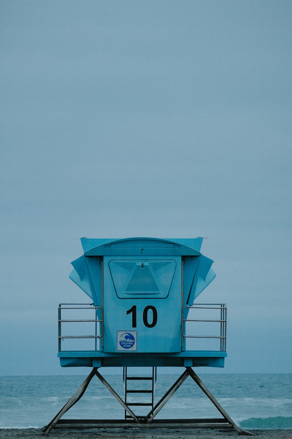 a lifeguard tower sitting on top of a sandy beach