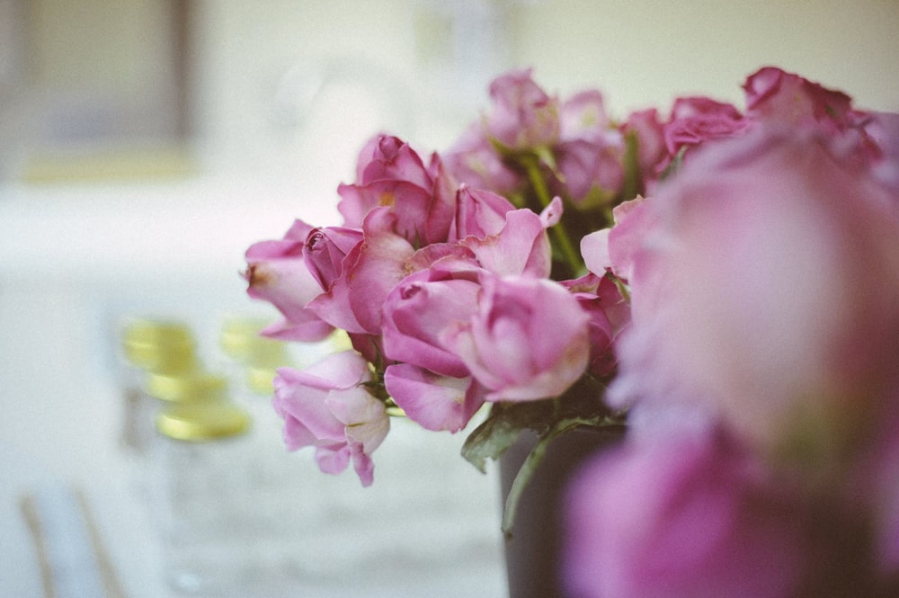 Un jarrón lleno de flores rosadas encima de una mesa