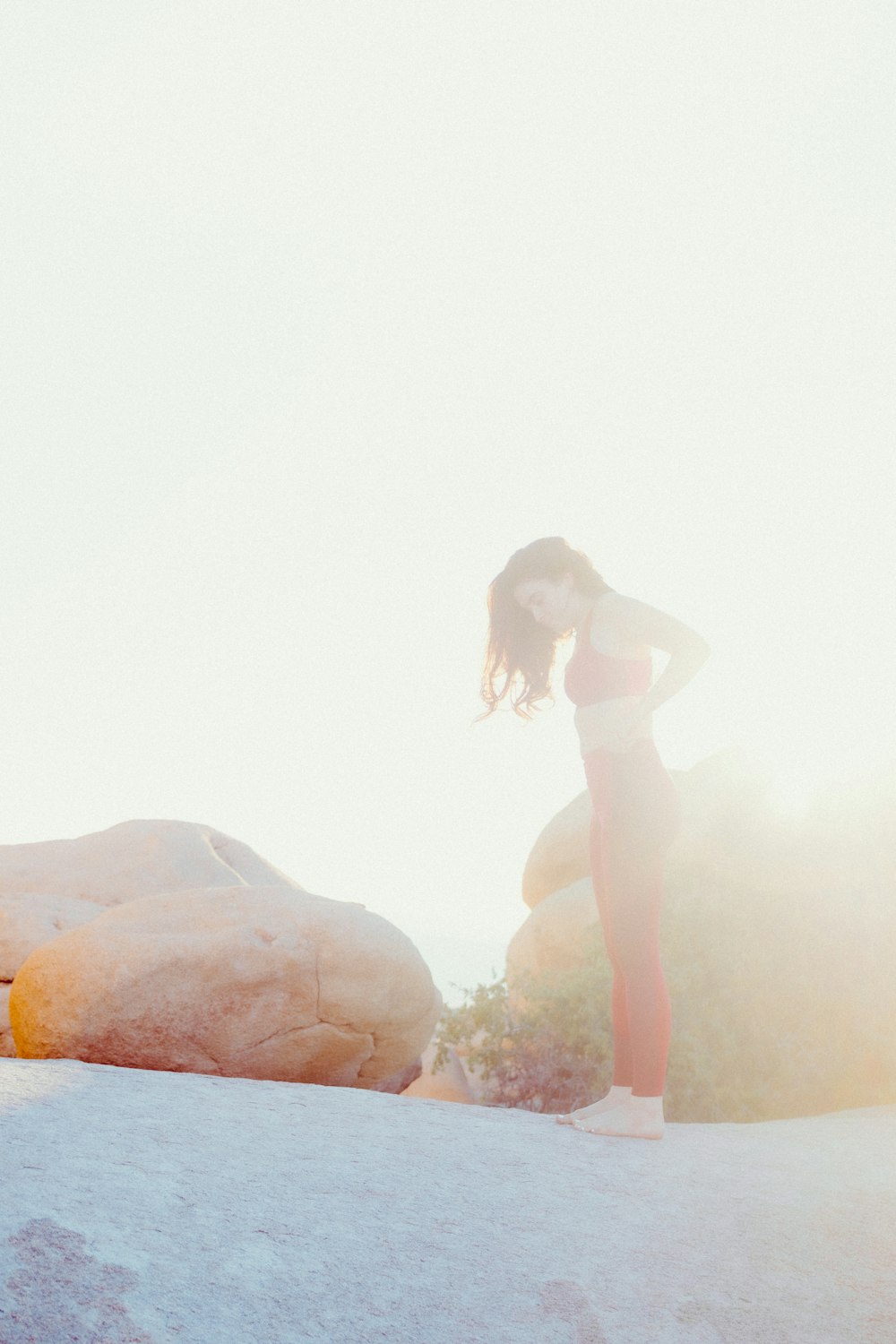 a woman in a bathing suit standing on a rock