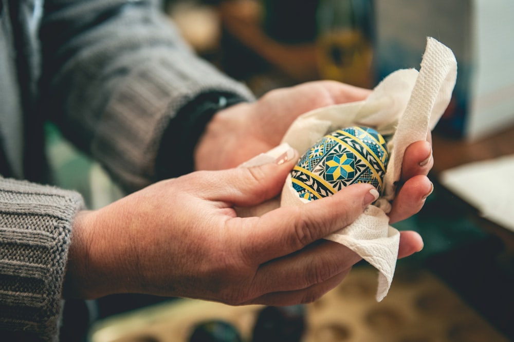 a person holding an easter egg in their hand