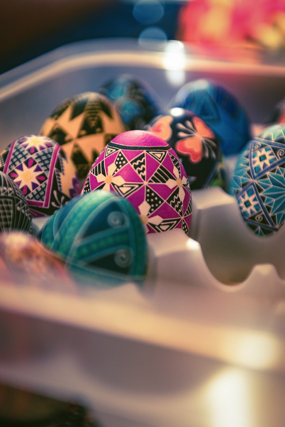 a plastic container filled with colorfully decorated eggs