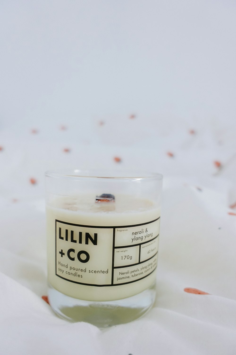 a candle sitting on top of a white sheet