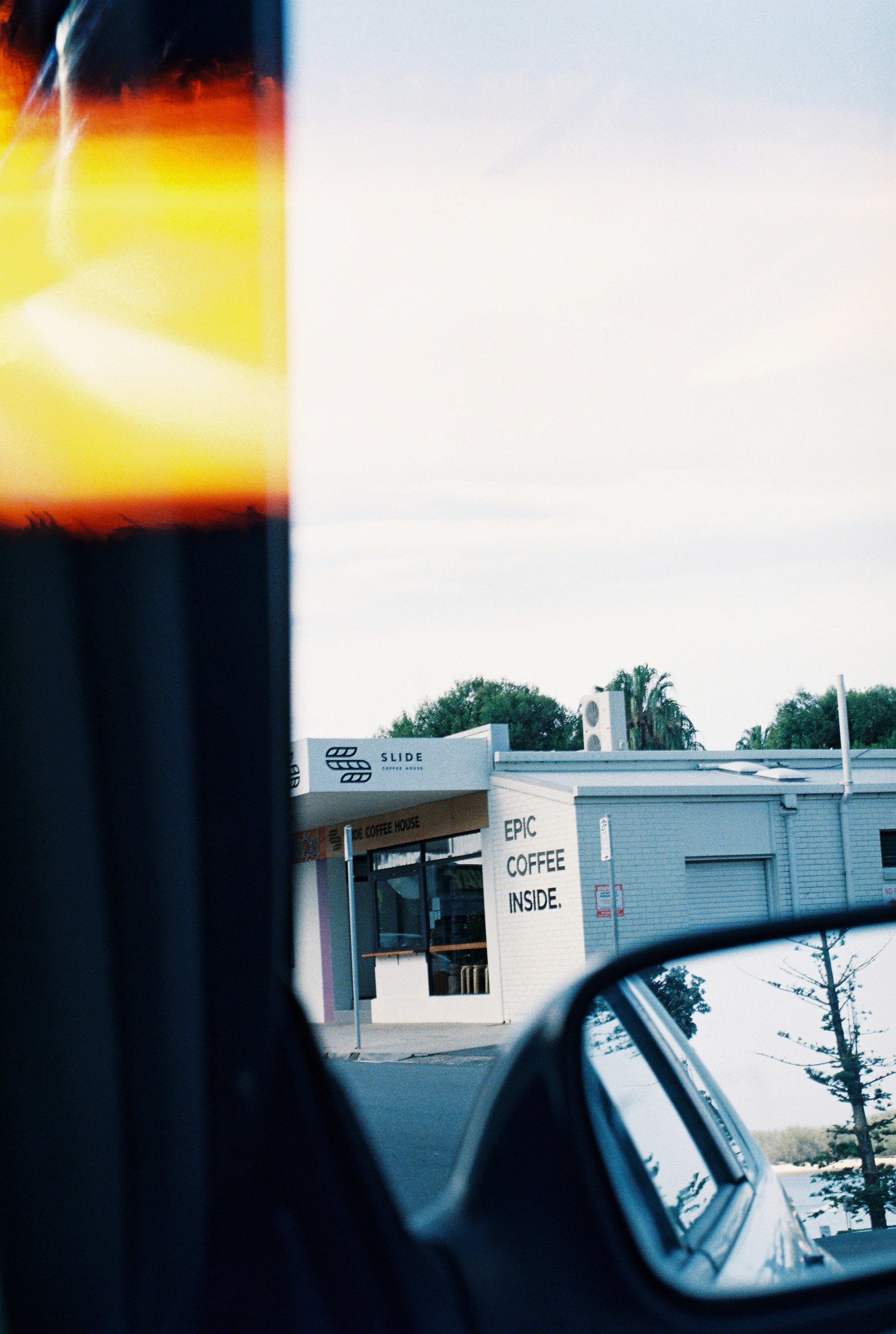 a side view mirror of a car with a building in the background