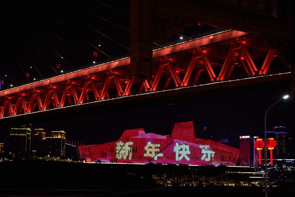 a bridge lit up with red lights at night