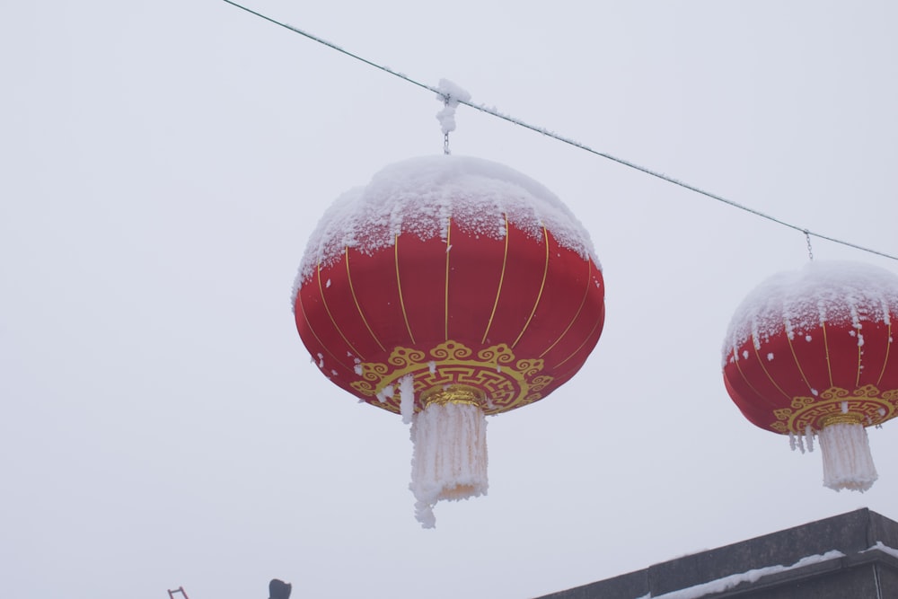 a couple of red lanterns hanging from a wire