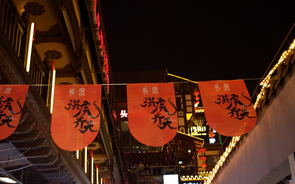 a city street at night with chinese signs hanging from the buildings