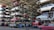 Numerous stacked rows of disassembled cars are placed on metal structures in what appears to be a scrapyard. Many of the cars are missing parts like wheels and doors.