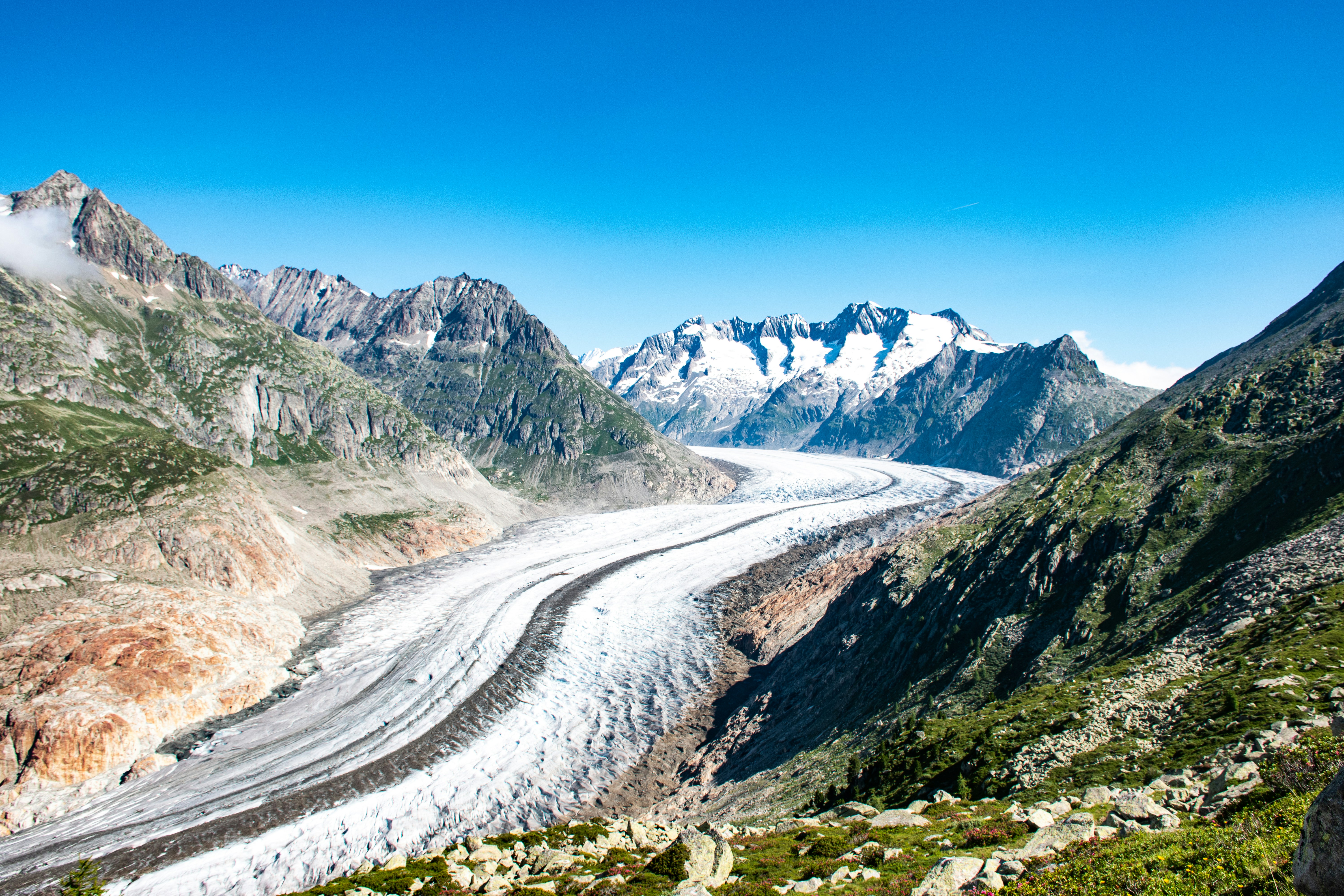 un glacier traversant une vallée entourée de montagnes