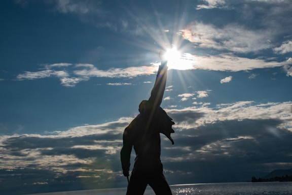a man standing on top of a beach next to the ocean