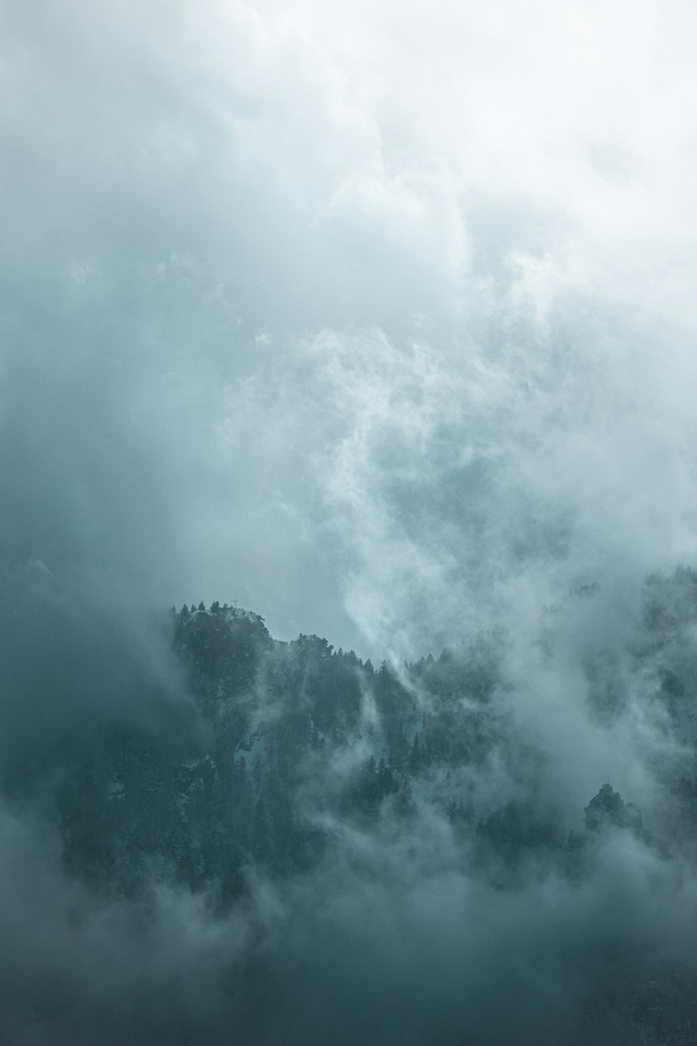 a view of a mountain covered in clouds