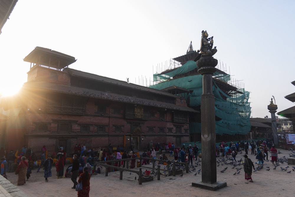 a group of people standing around a building under construction