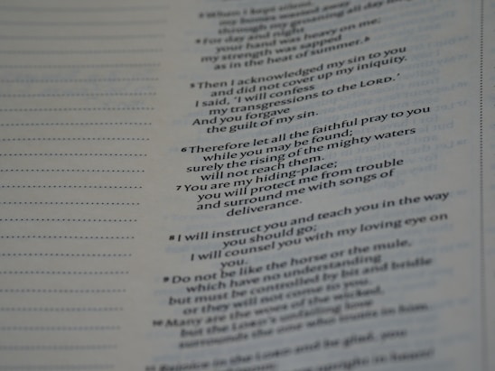 A close-up view of a book or document showing a section of text printed in a serif font. The text contains numbered lines, potentially verses or key points, and is formatted in a column layout. The background is a light color, typical of paper. The text on the left shows dotted lines, possibly for notes or annotations.