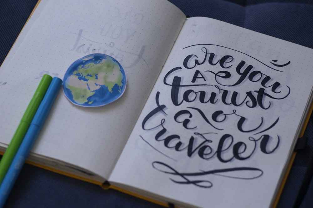a notebook with a pen and a drawing of the earth