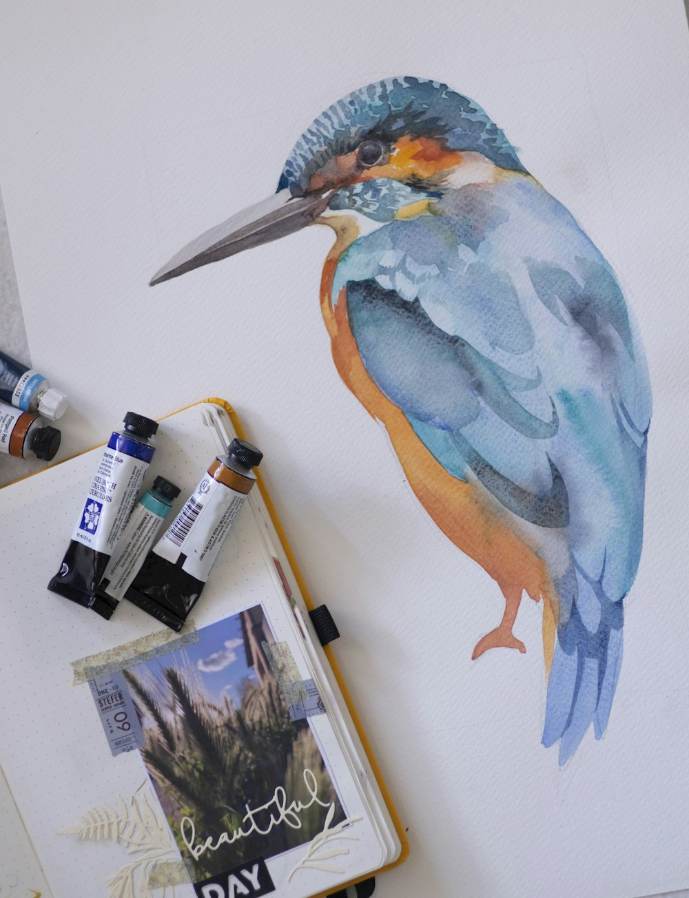 a watercolor painting of a bird on a canvas