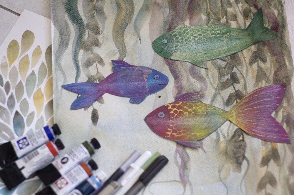 ein Gemälde von zwei Fischen und einigen Aquarellen