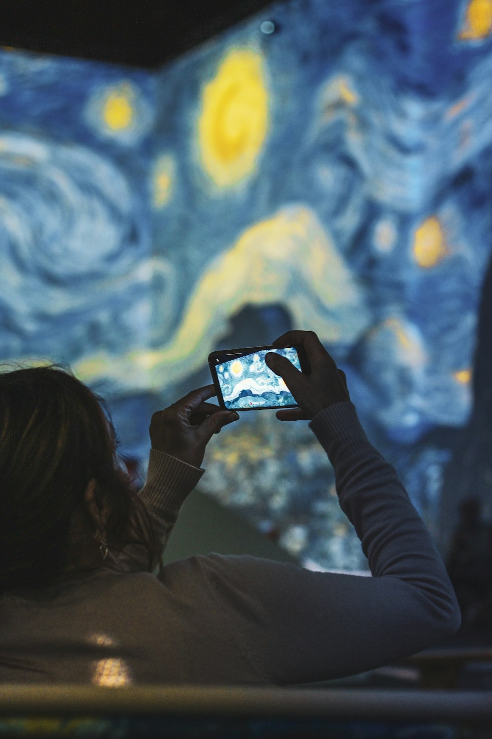 a person taking a picture of a painting with a cell phone