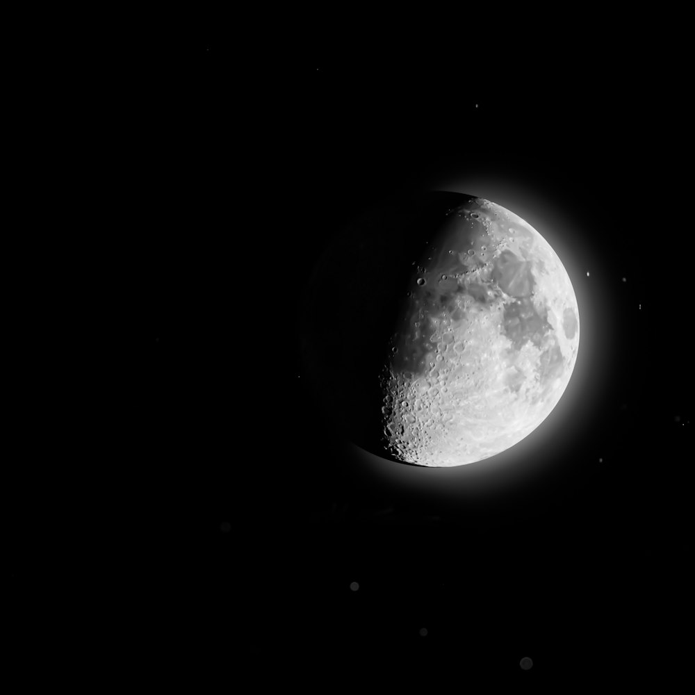 a half moon is seen in the dark sky