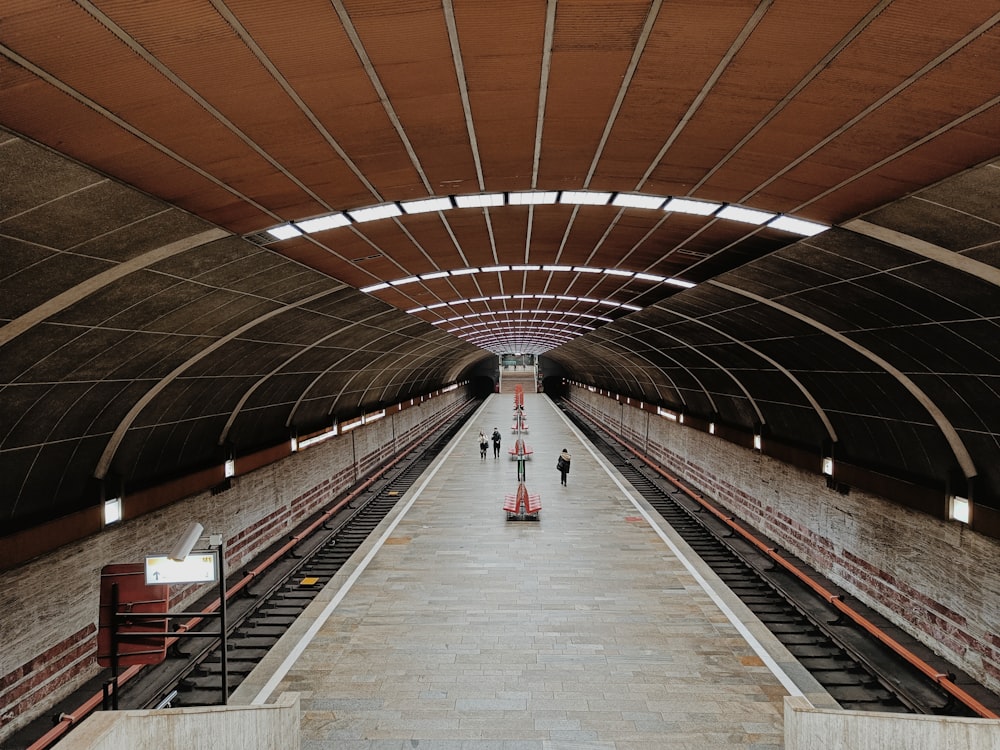 a train station with people walking on the platform