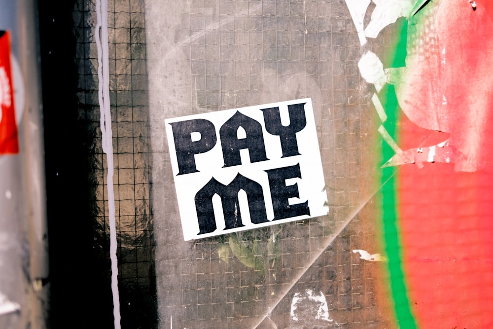 a pay me sticker on the side of a building