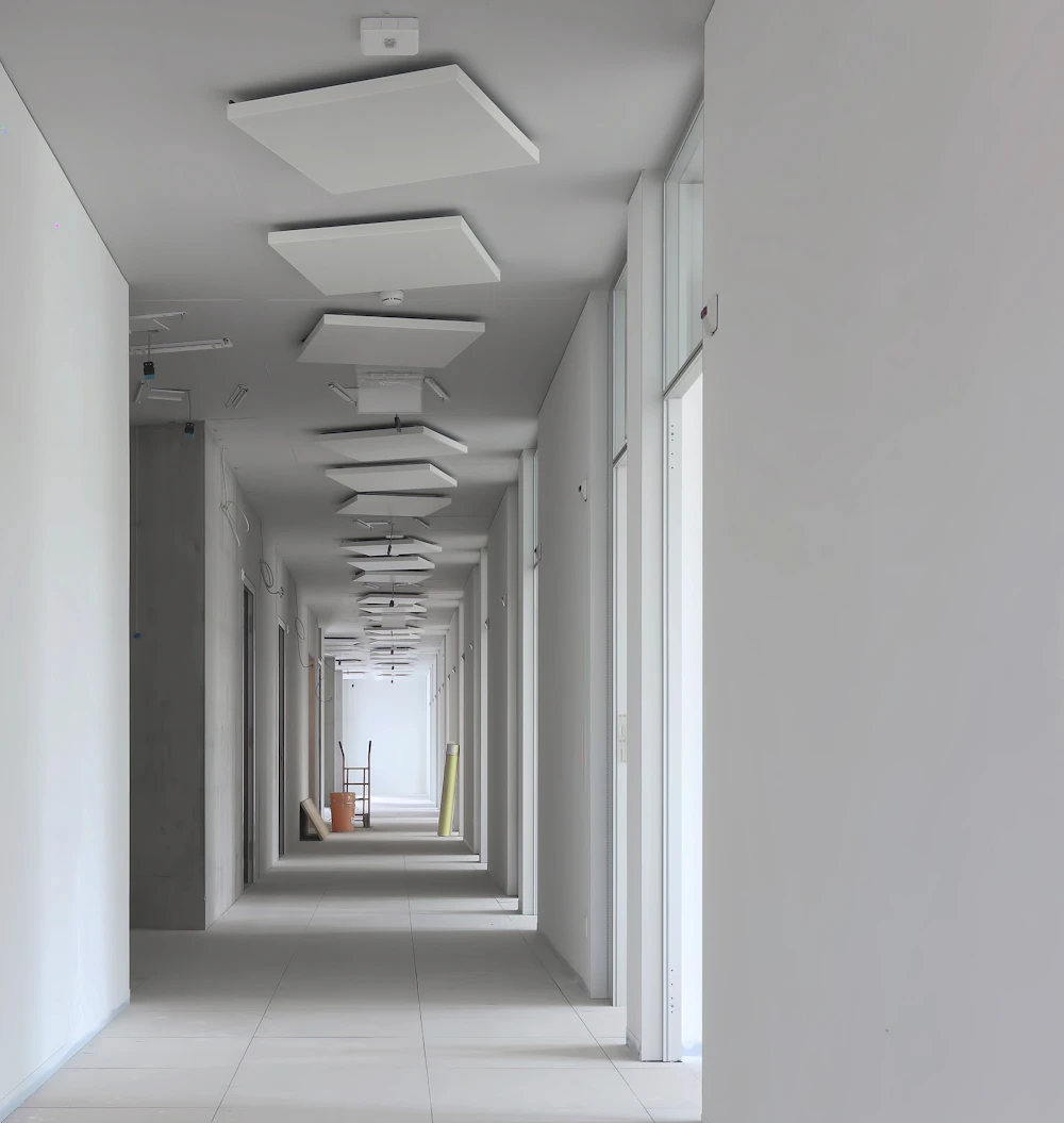 Long hallway with smooth white walls and ceiling lights