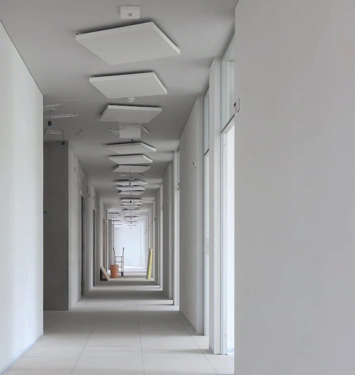 Long hallway with smooth white walls and ceiling lights
