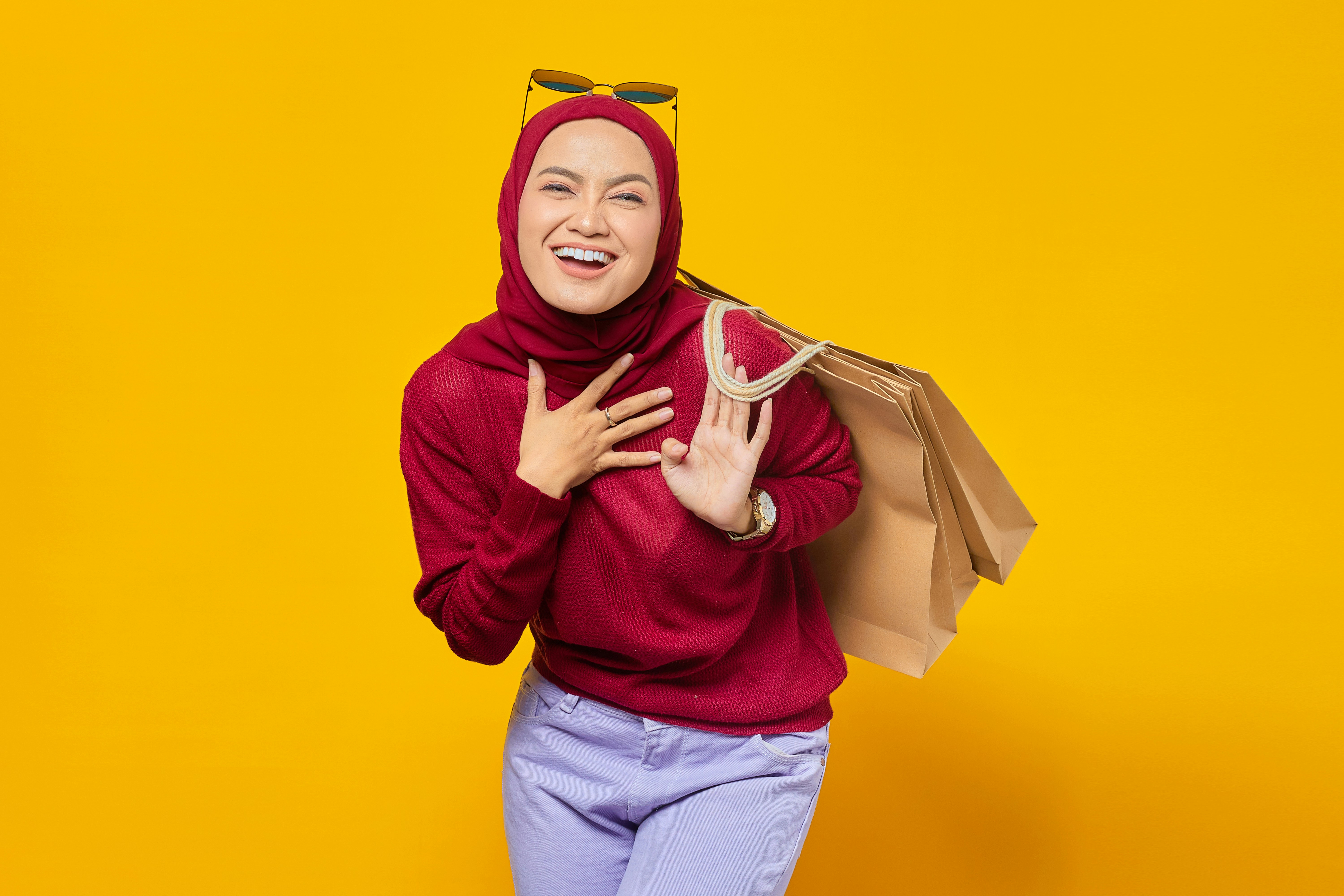 a woman in a red sweater holding shopping bags