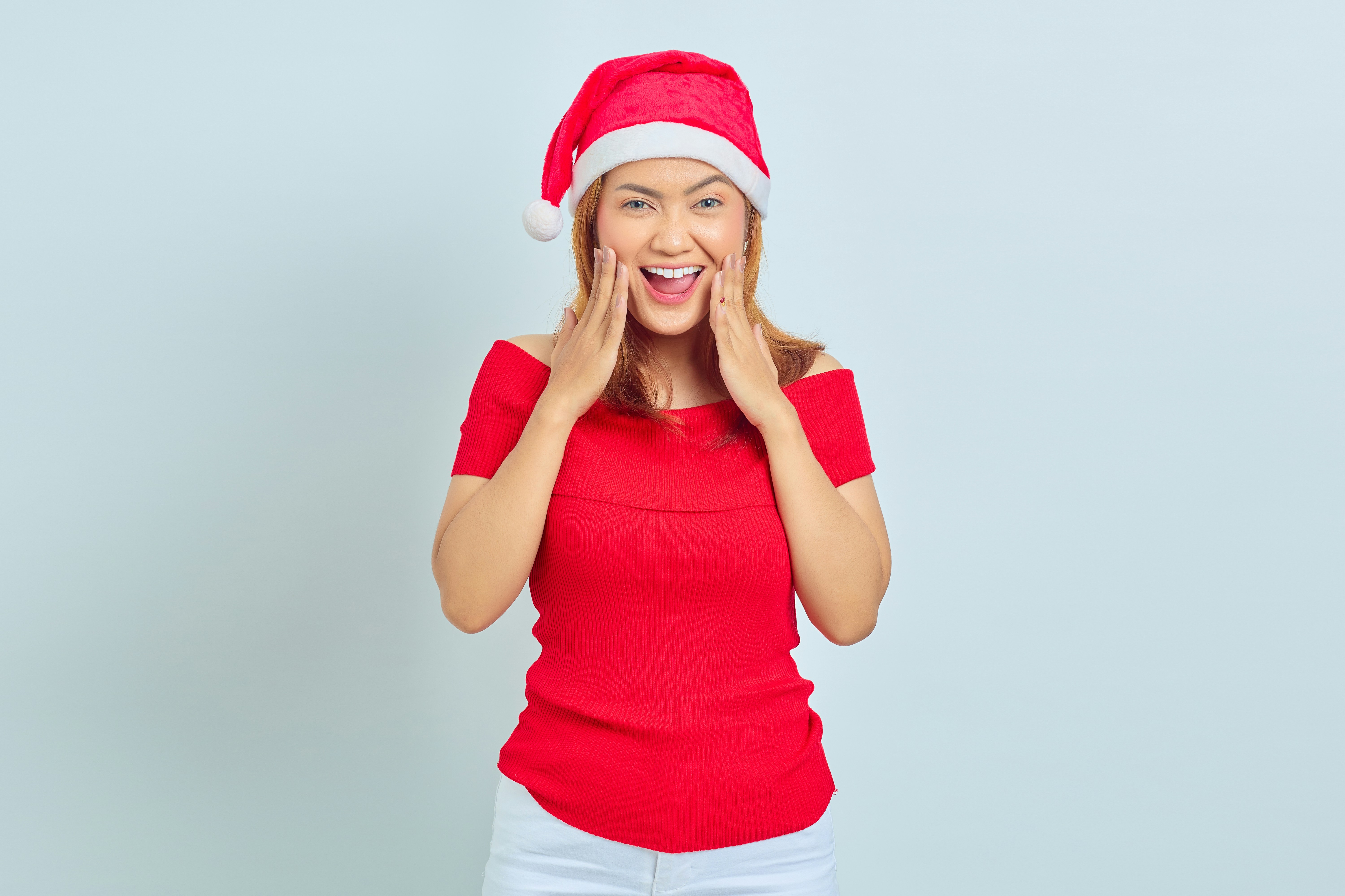 a woman wearing a santa hat making a funny face