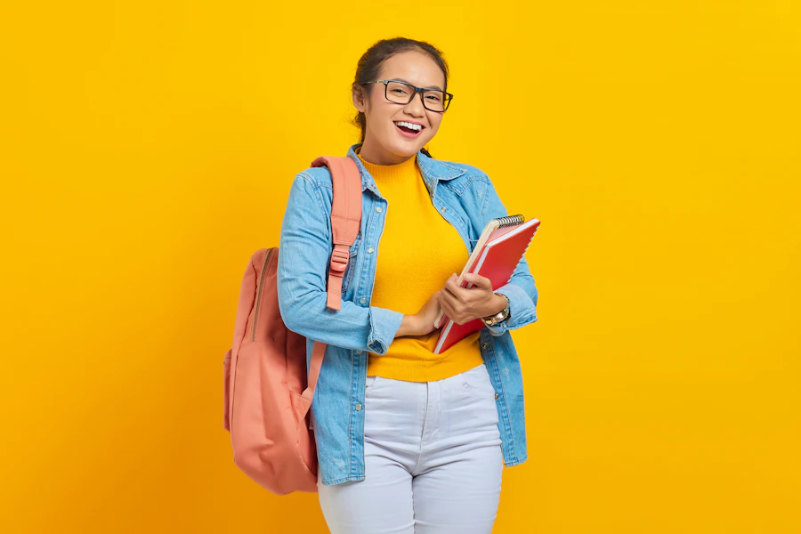 Estudiante sonriendo con mochila y cuaderno