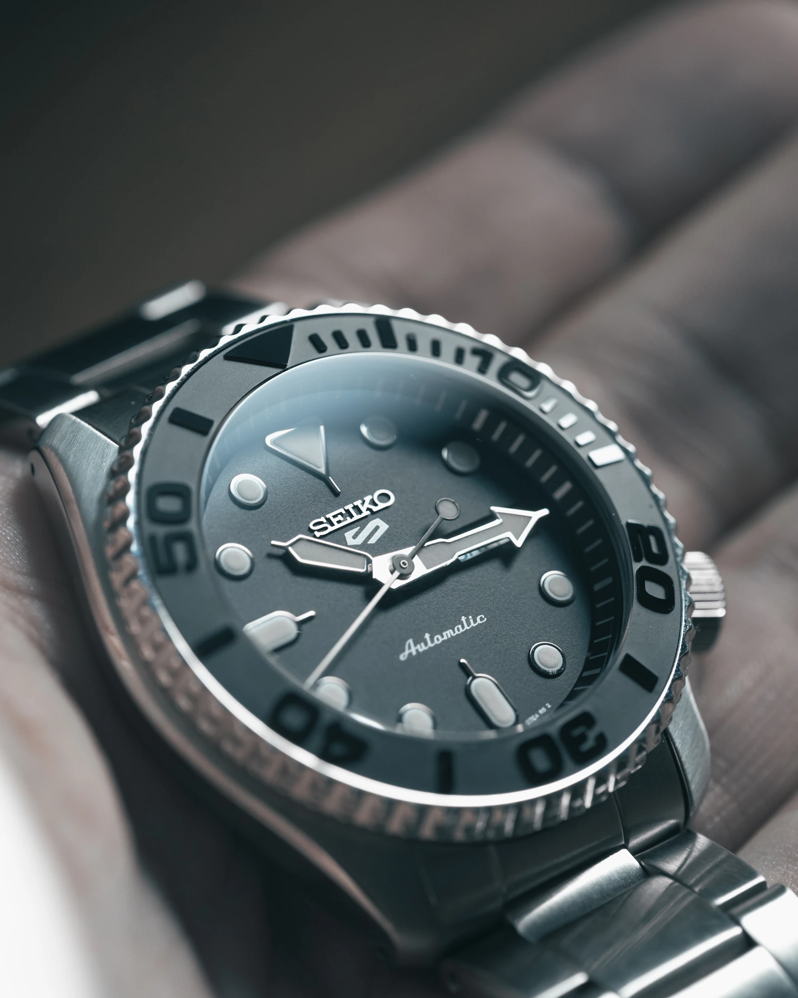 Seiko 5 Sports grey dial held in hand
