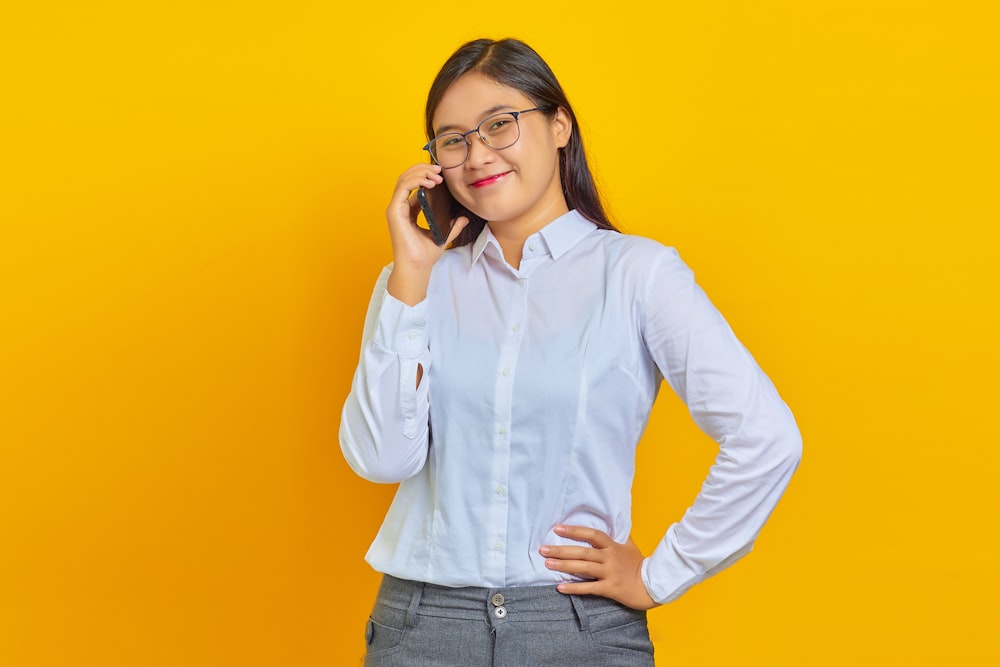 a woman in glasses talking on a cell phone