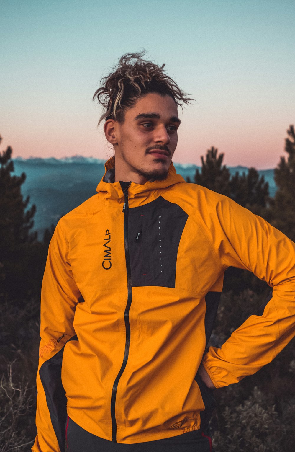 a man with dreadlocks wearing a yellow jacket